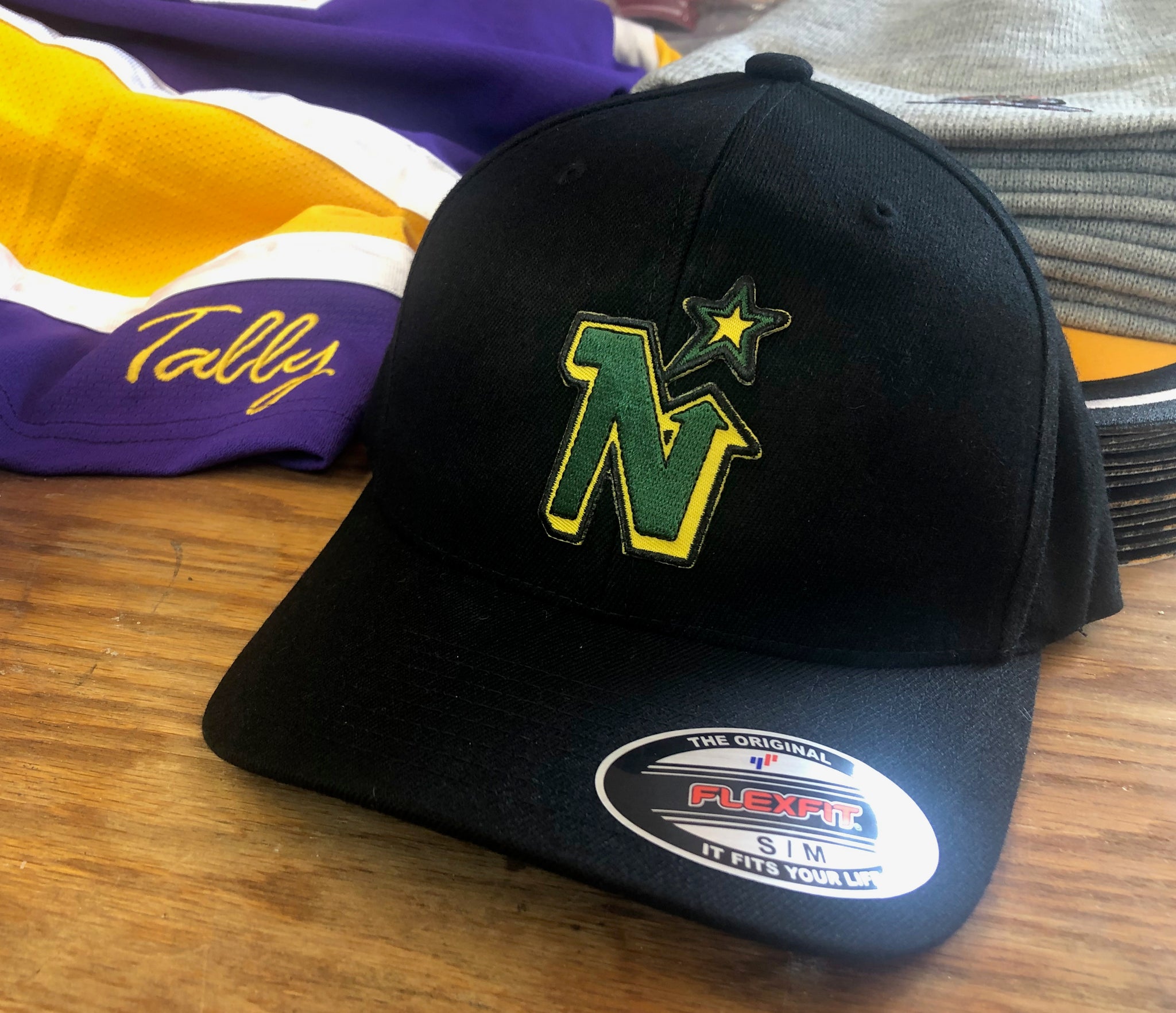 Flex-Fit Hat with a (Black) Tally Northstars logo – Jerseys Hockey crest $39 