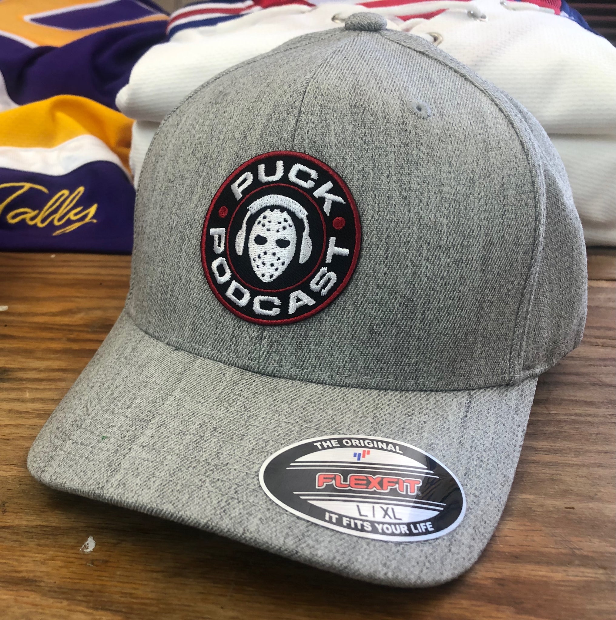 Flex-Fit Hat with the Puck Hockey Jerseys (Heather) logo crest – $39 Tally Podcast 